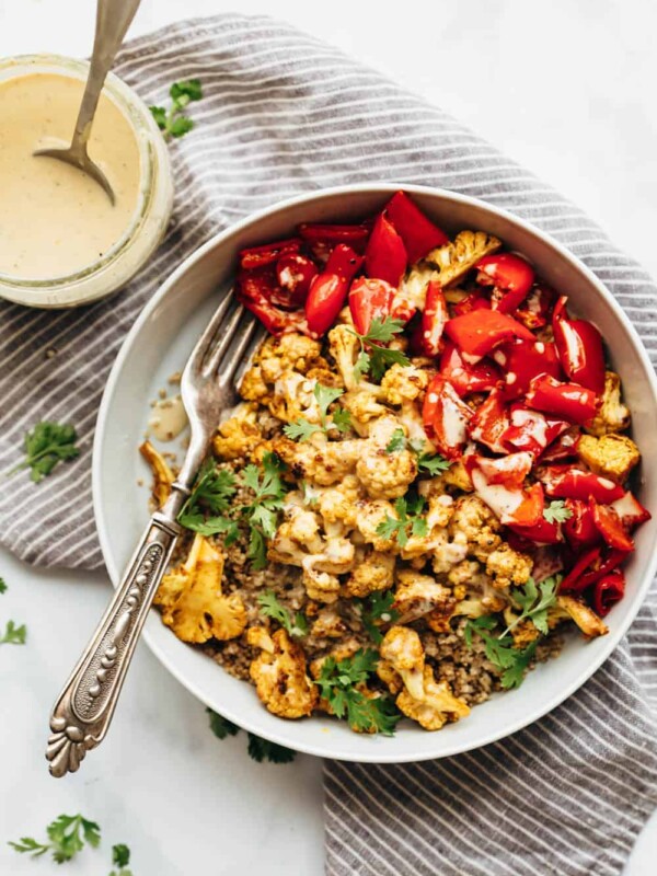 Curried roasted cauliflower bowl with tahini dressing drizzled on top