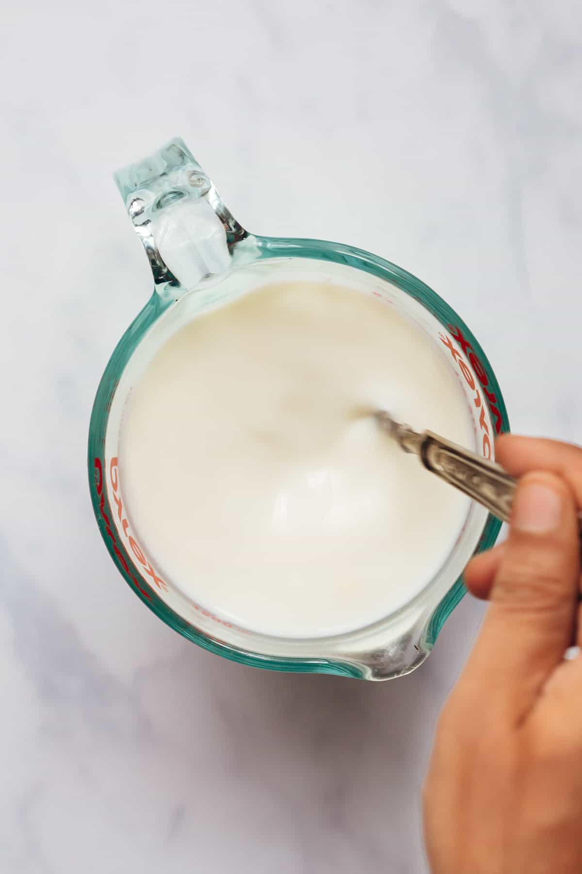 Stirring the ingredients to make buttermilk at home.