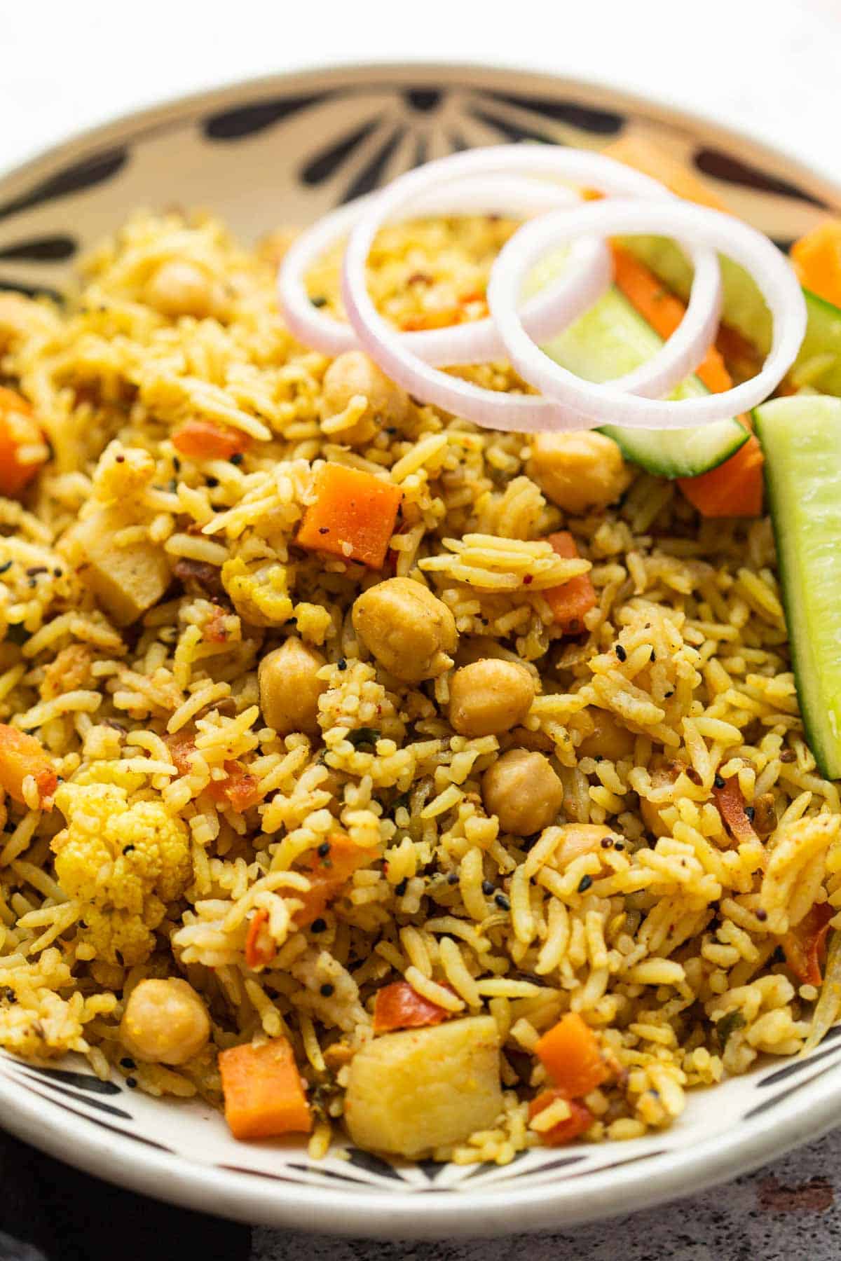 Kabuli Chana Pulao served in a bowl with onions and a salad