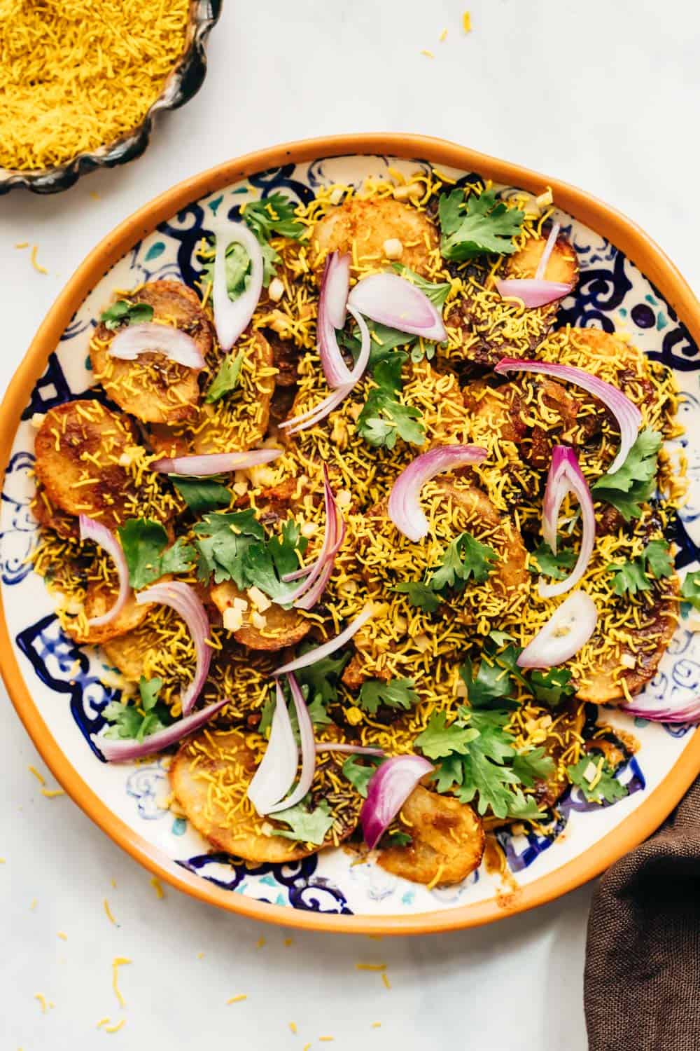 Closeup of easy aloo chaat - delhi style served on a plate with sev and lime on the side