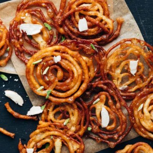 Overhead shot of crispy homemade jalebis with almond flakes sprinkled on top