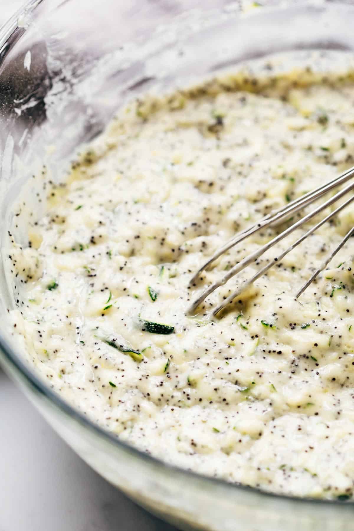 Lemon Zucchini Bread cake batter in a bowl with a whisk