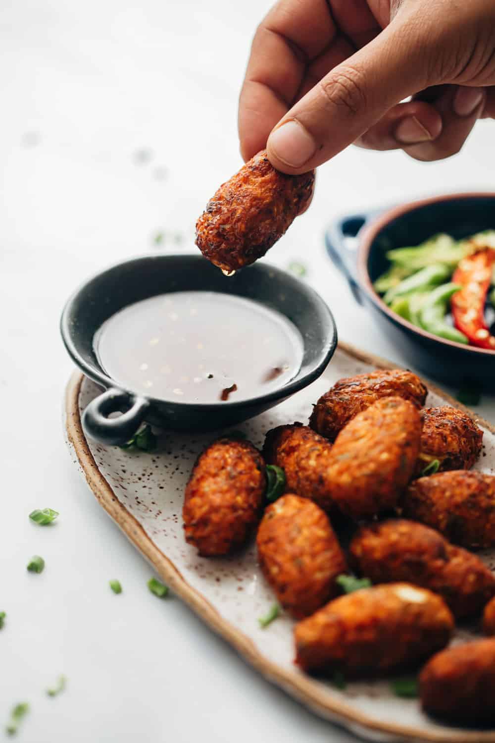 Dipping crispy veg nuggets in sichuan sauce