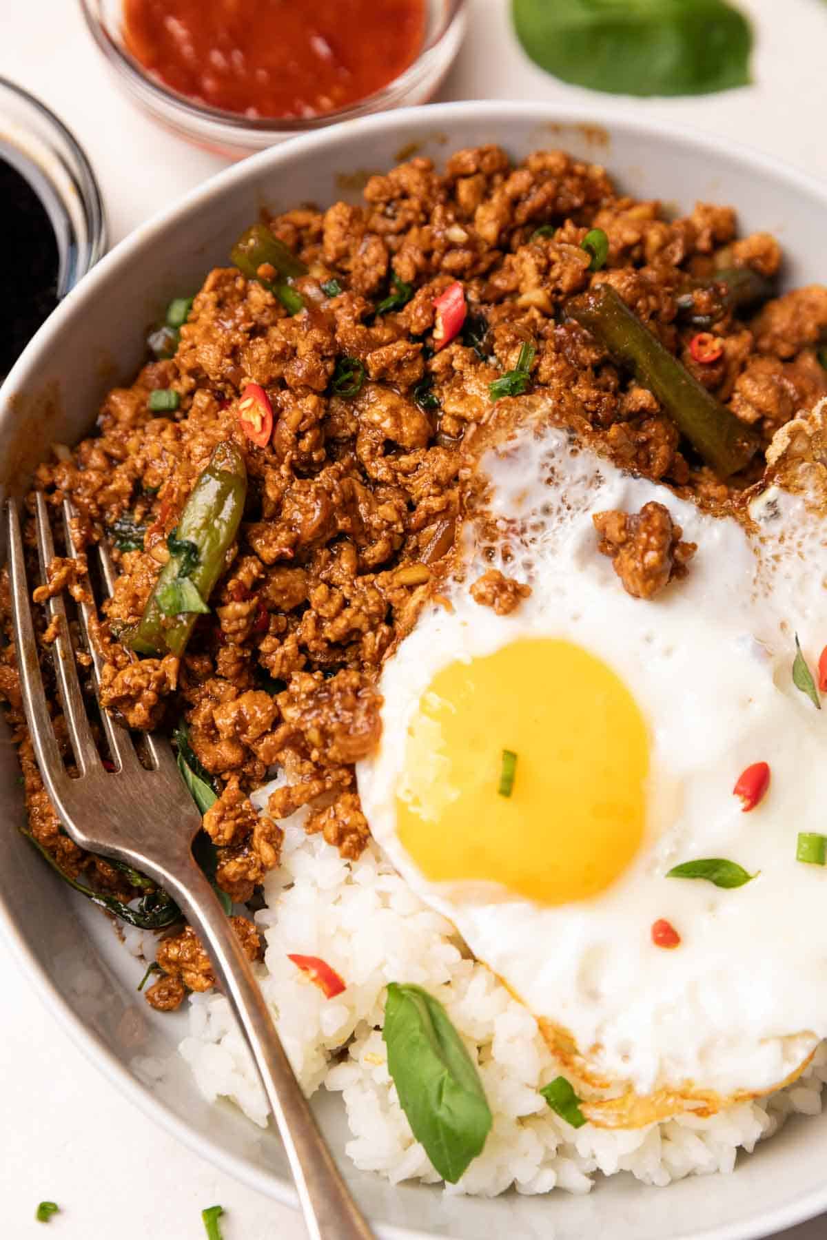 thai basil chicken served with steamed rice and an egg