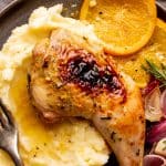 Spatchcocked chicken leg served over mashed potatoes with jus