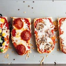 Toasted french bread pizza toasts straight from the oven on a baking sheet