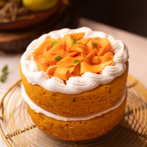 an image of a whole eggless mango cake placed on a wire rack