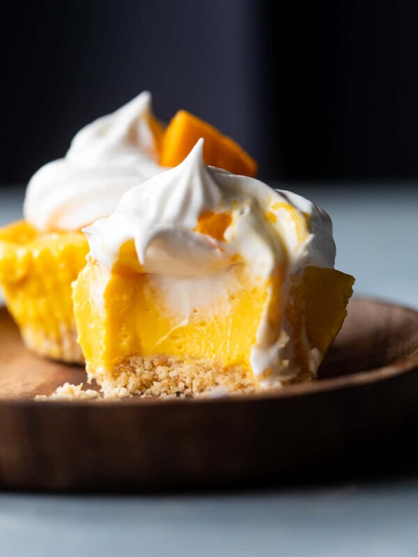 Closeup of a bite takes out of mini mango cheesecakes to show texture
