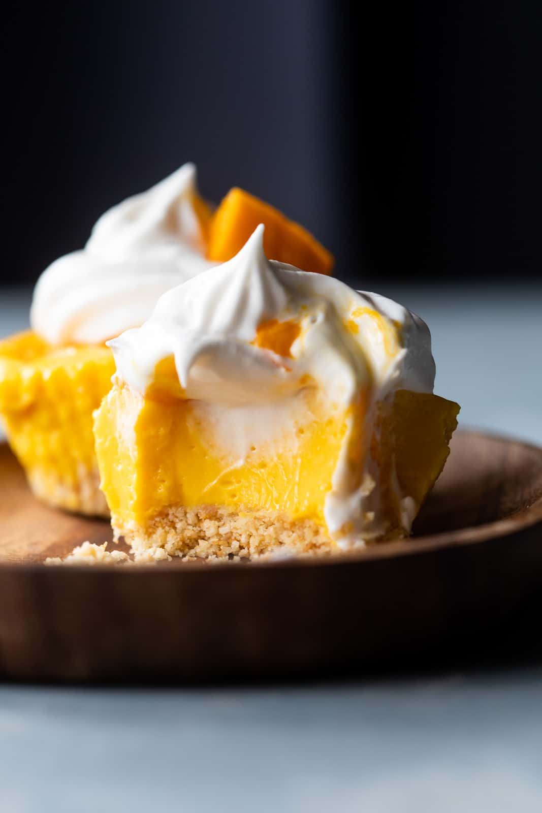 Closeup of a bite takes out of mini mango cheesecakes to show texture