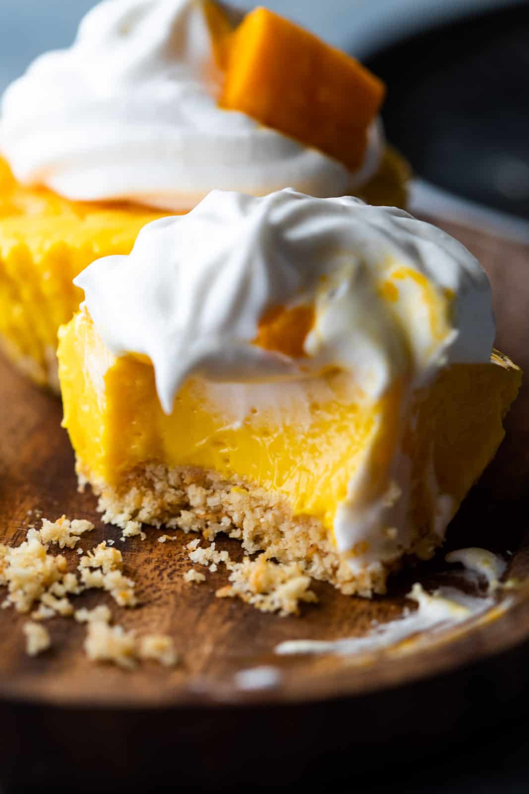 Closeup of a bite takes out of mini mango cheesecakes to show texture