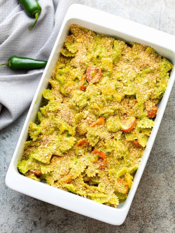 Baked pasta in jalapeno pesto in a white casserole dish straight from the oven