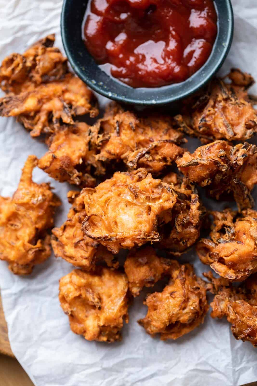 Onion Pakodas served on a platter with ketchup