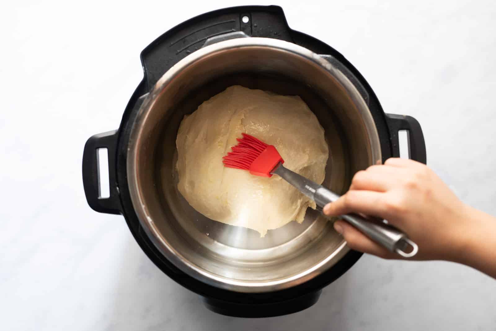 Kneaded dough kept in the instant pot and brushed with oil