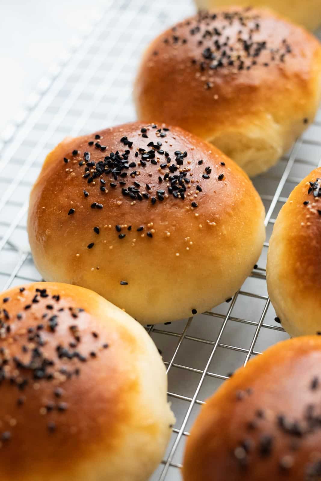 Bread buns laid out on a baking rack to cool