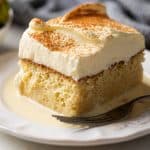 Eggnog tres leches served with strawberries on the side on a white plate