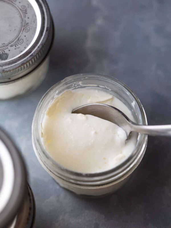 A spoon cutting into the yogurt to show the thick consistency of yogurt