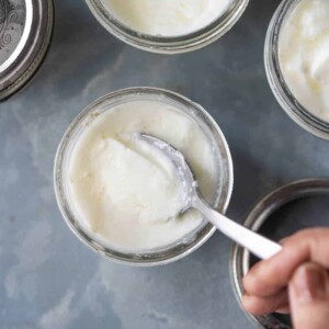 A spoon cutting into the yogurt to show the thick consistency of yogurt