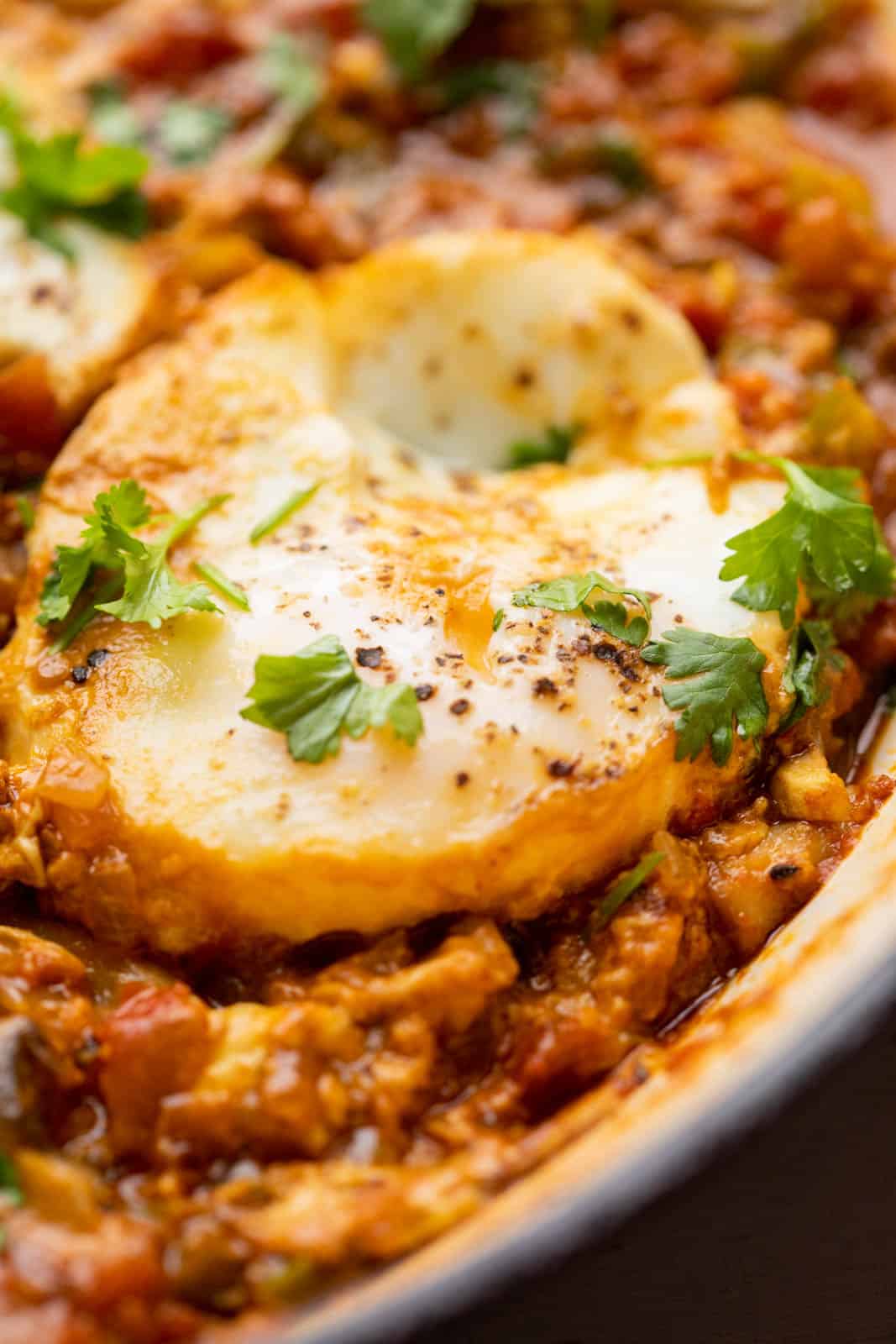Closeup of a poached egg in a spicy tomato sauce