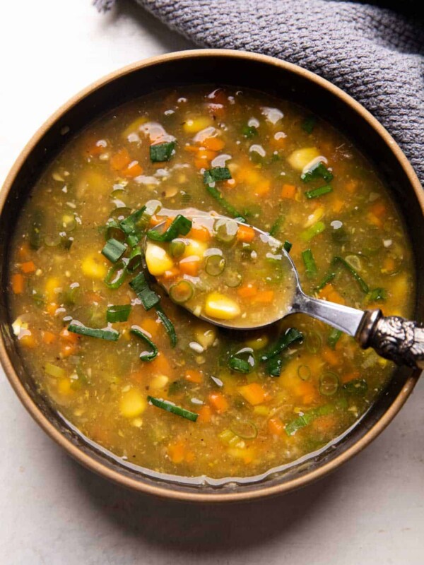 Vegetarian Sweet Corn Soup served in a black bowl with a spoon