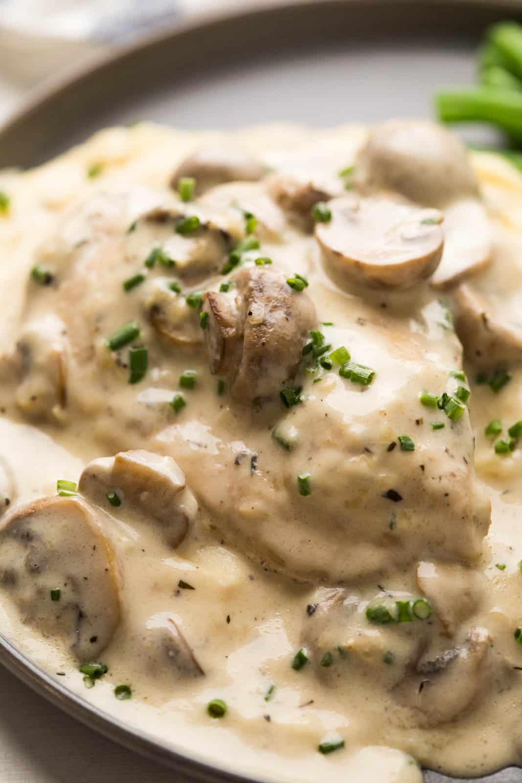 Closeup of mushroom sauce ladled over chicken breast