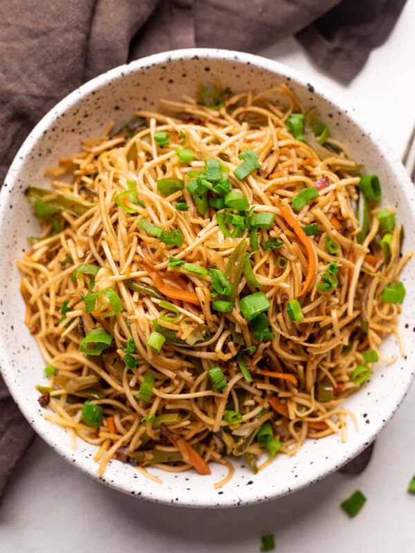 Vegetable hakka noodles served in a white speckled bowl