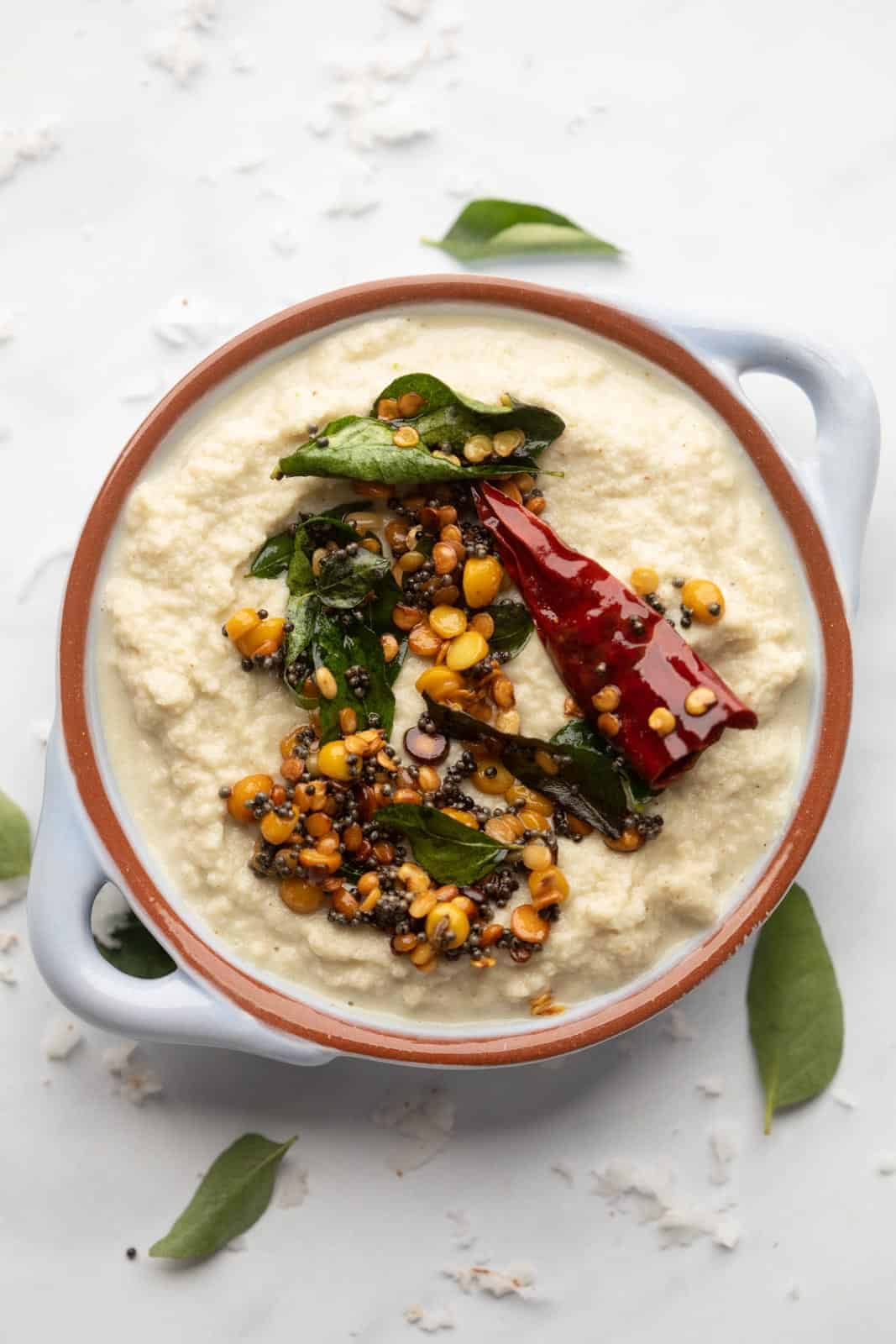 Coconut Chutney served in a light blue bowl with tempering on top