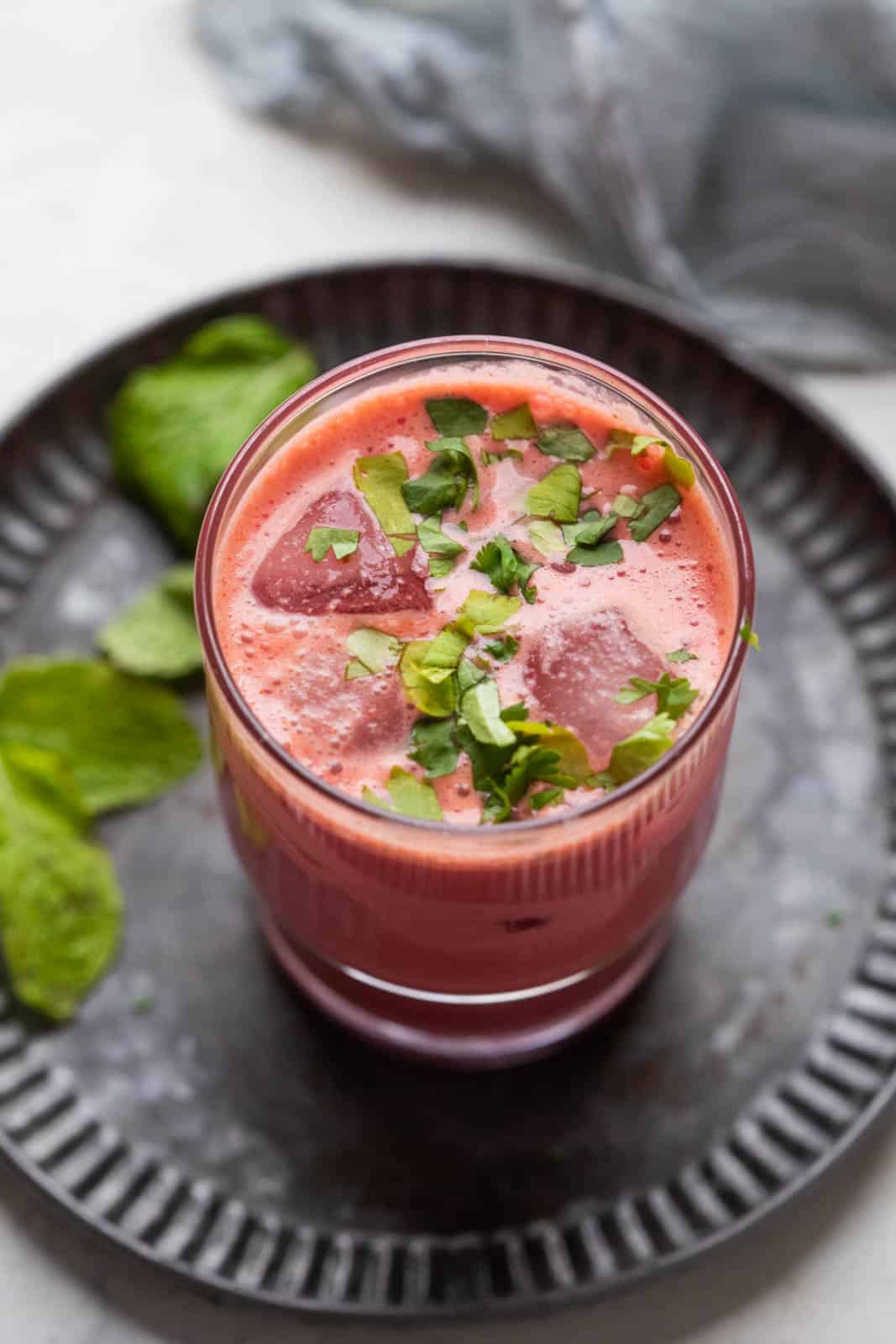 beetroot chaas with ice cubes served in a glass on a metal tray