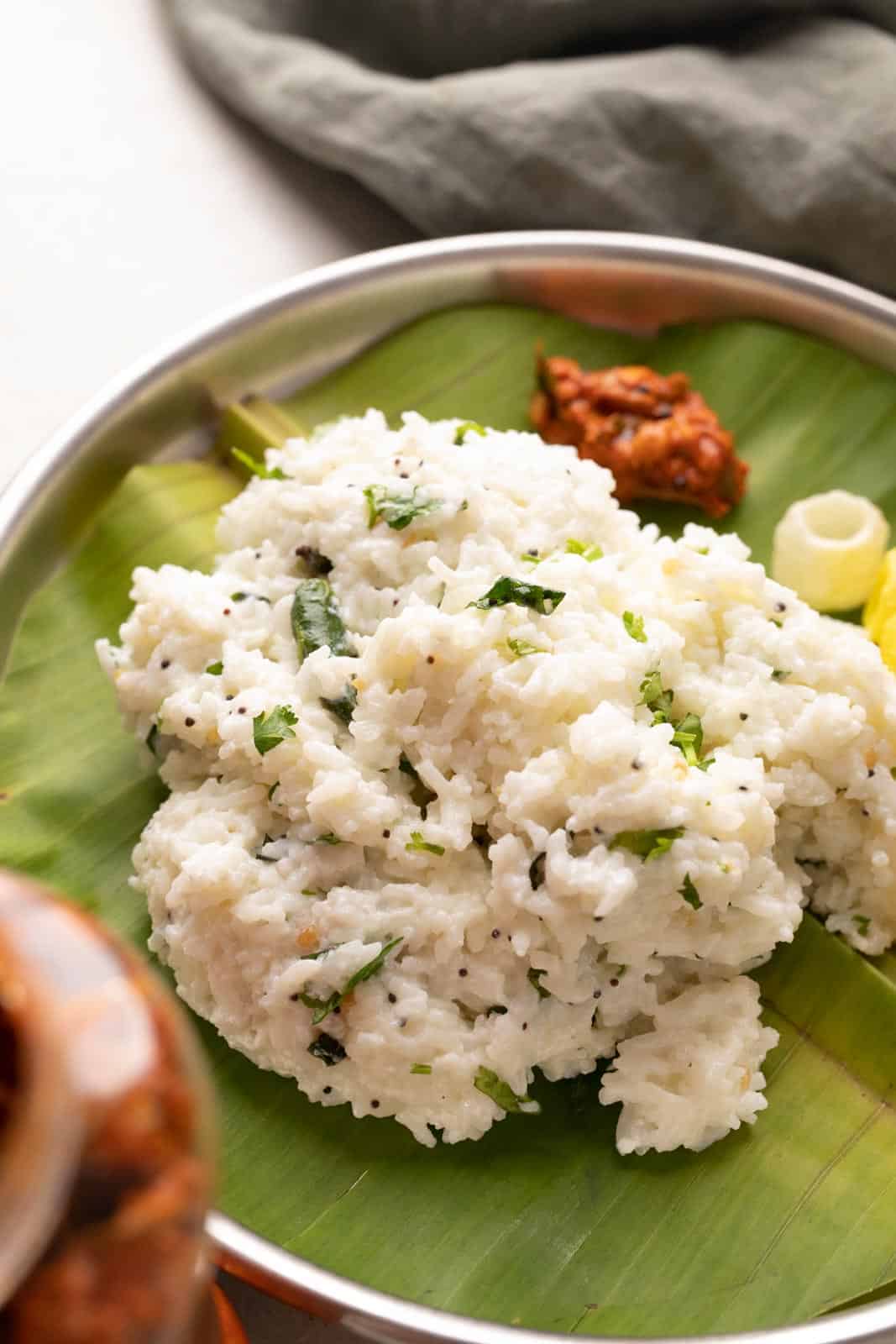Curd rice served on a plate with pickle and fryums
