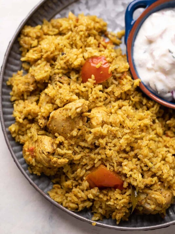 Chicken Pulao served on a grey plate with raita