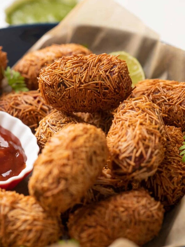 Veg Cutlets served in a blue bowl with green chutney and ketchup