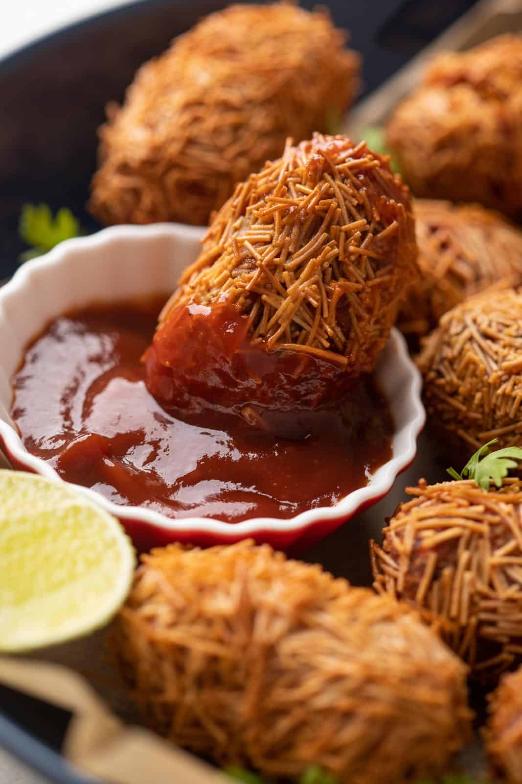Veg cutlet dipping into tomato ketchip