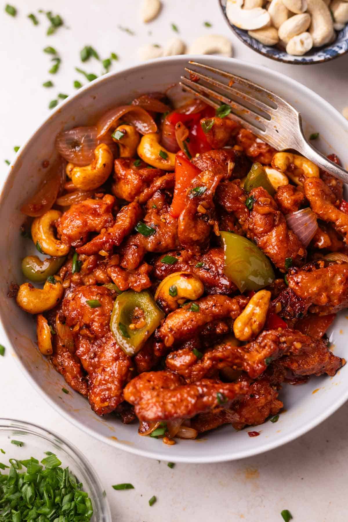 dragon chicken served in a white bowl with a fork