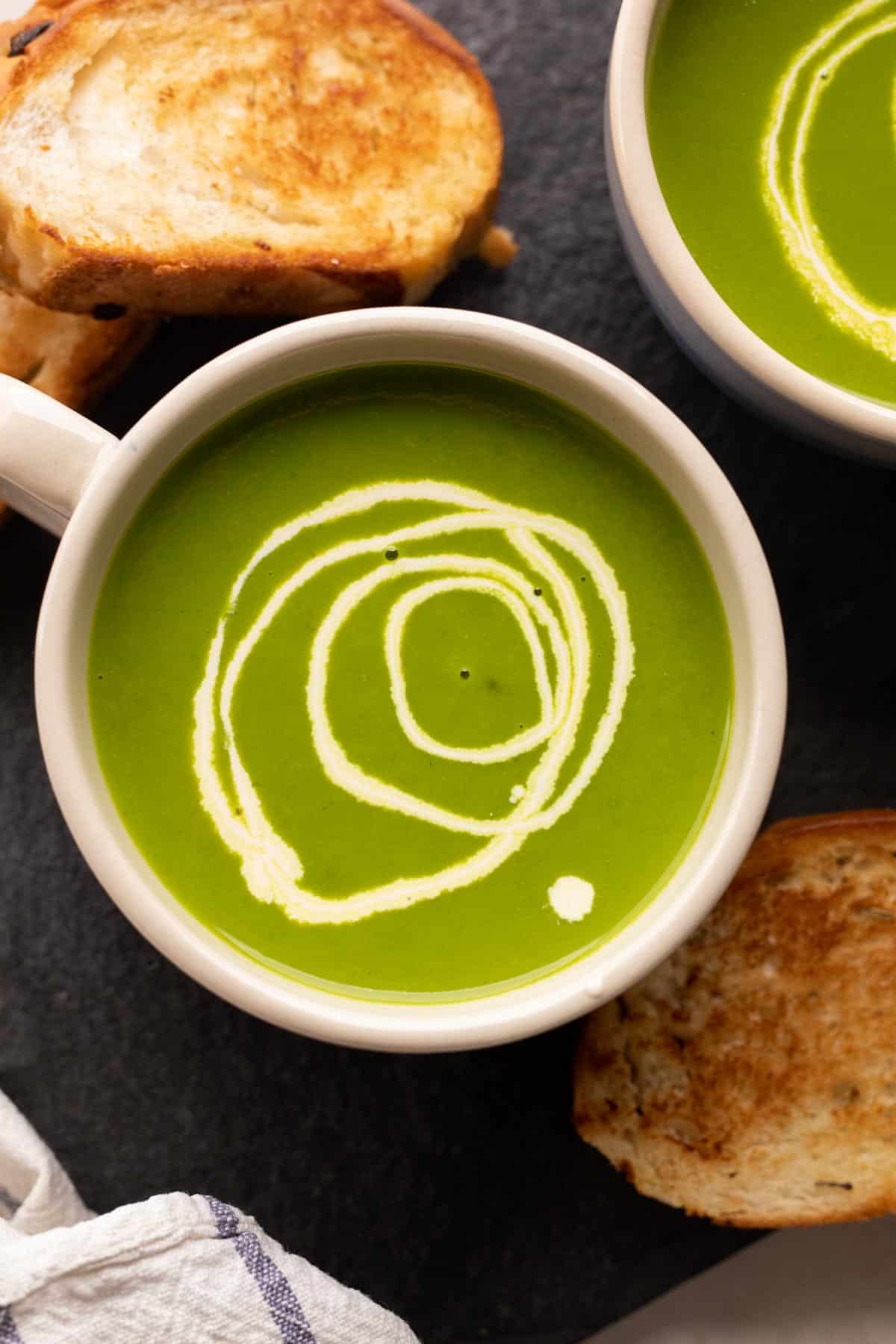 Spinach Soup served in a bowl with toasted bread on the side