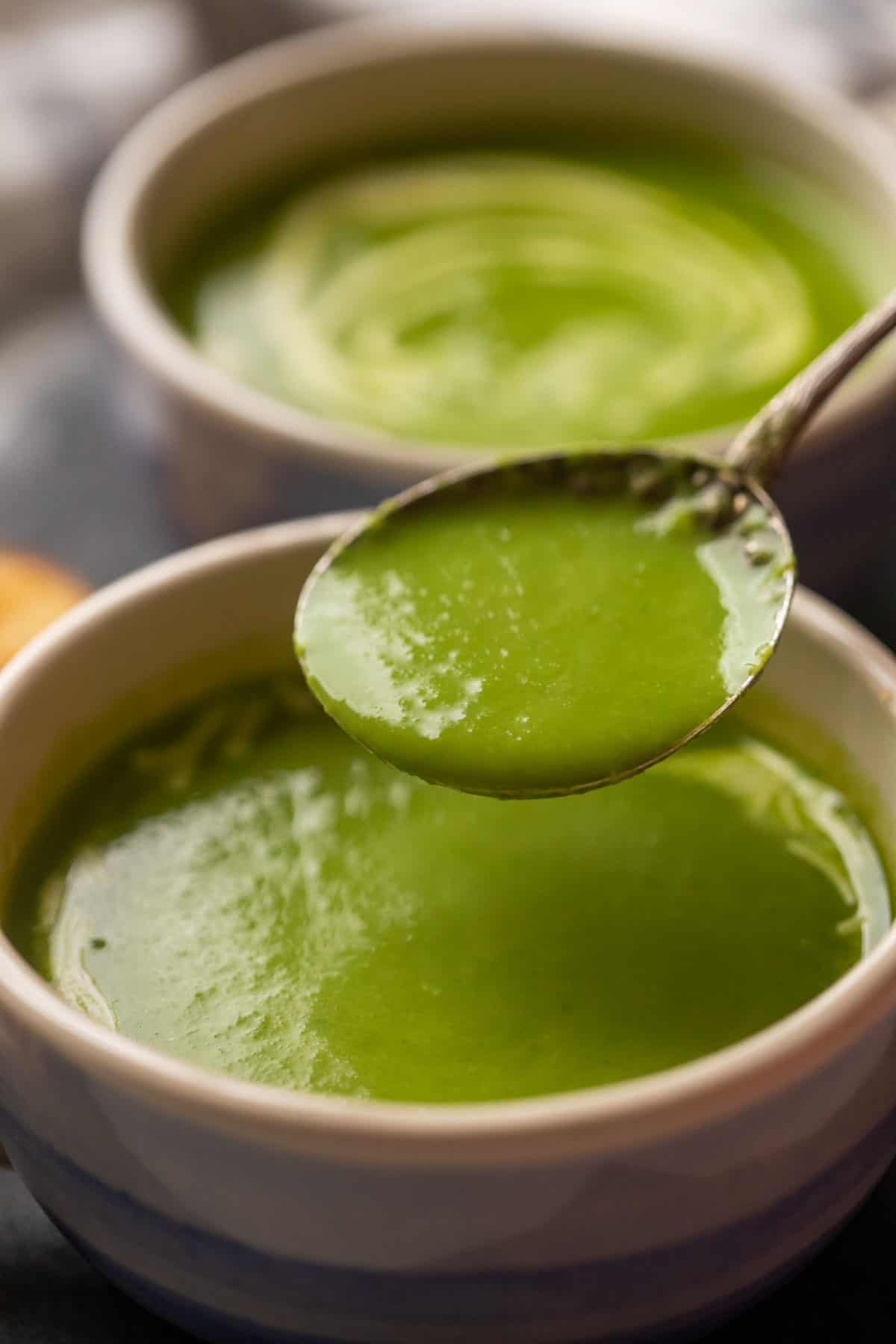 Picture of a spoonful of spinach soup being taken out of the bowl