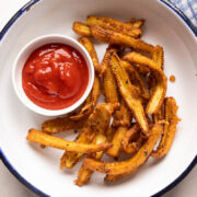 Crispy baby corn fry served in a white plate with ketchup on the side