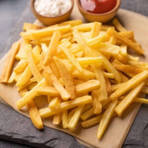 Plate of french fries served with a mayonnaise dip and ketchup