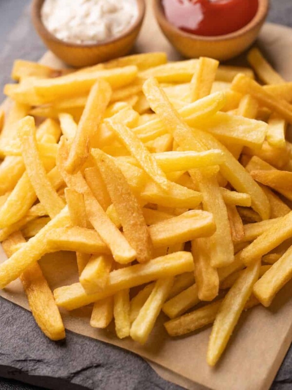 Plate of french fries served with a mayonnaise dip and ketchup