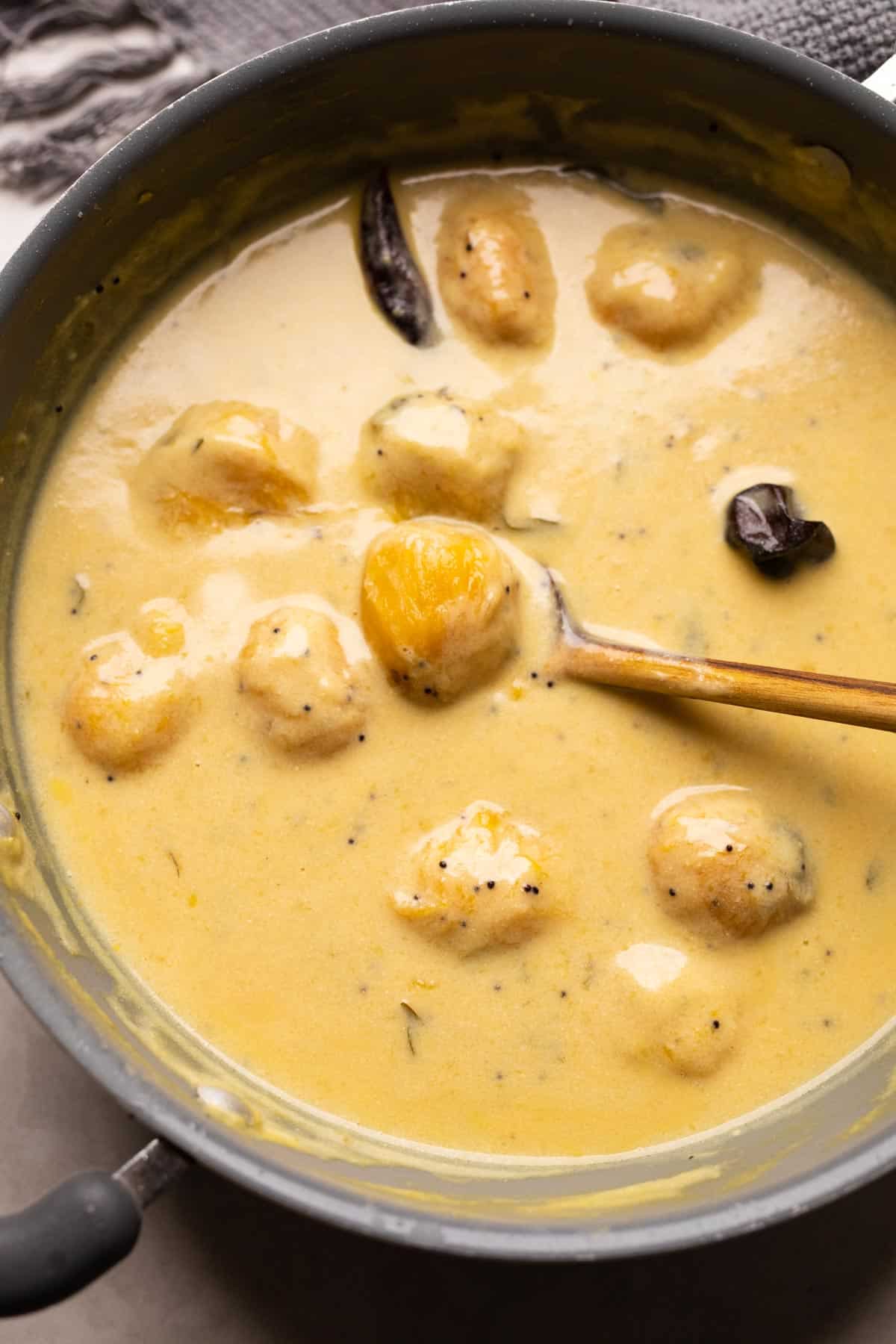 Mango Kadhi pictured in the pan it was made in with a ladle on the side