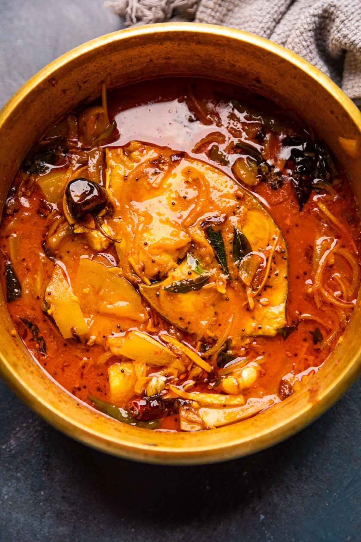 Raw Mango Fish Curry served in a brass pot that it was cooked in