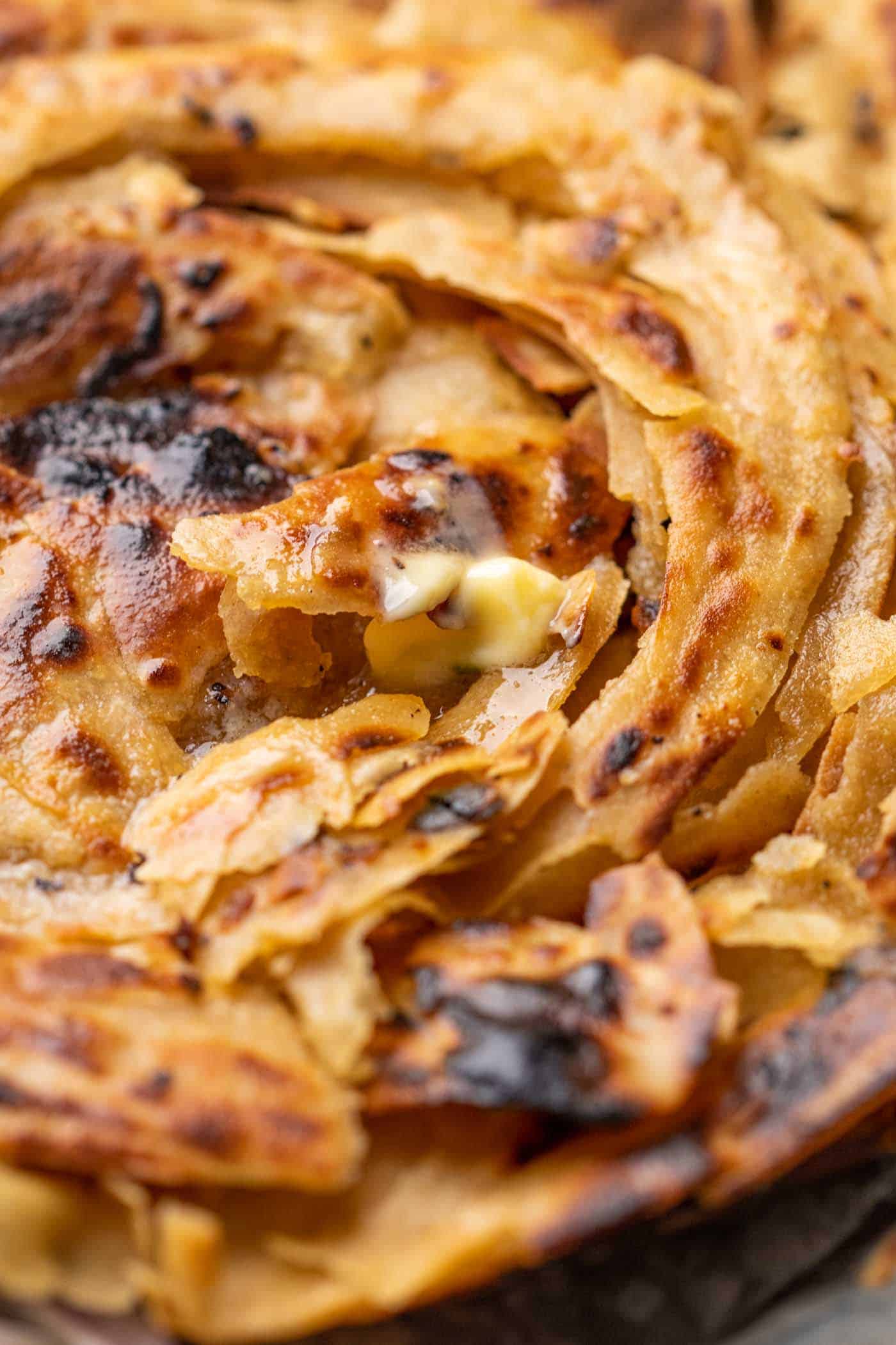 Close up of all the flaky layers of lachha paratha
