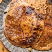 Puran polis served on a silver platter drizzled with saffron and ghee