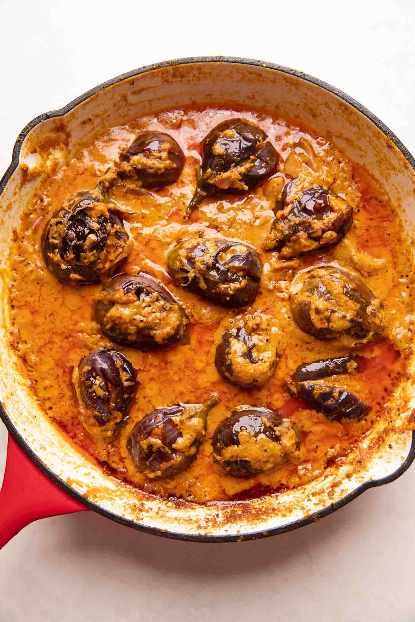 Picture of stuffed brinjal curry in a red enamel pan
