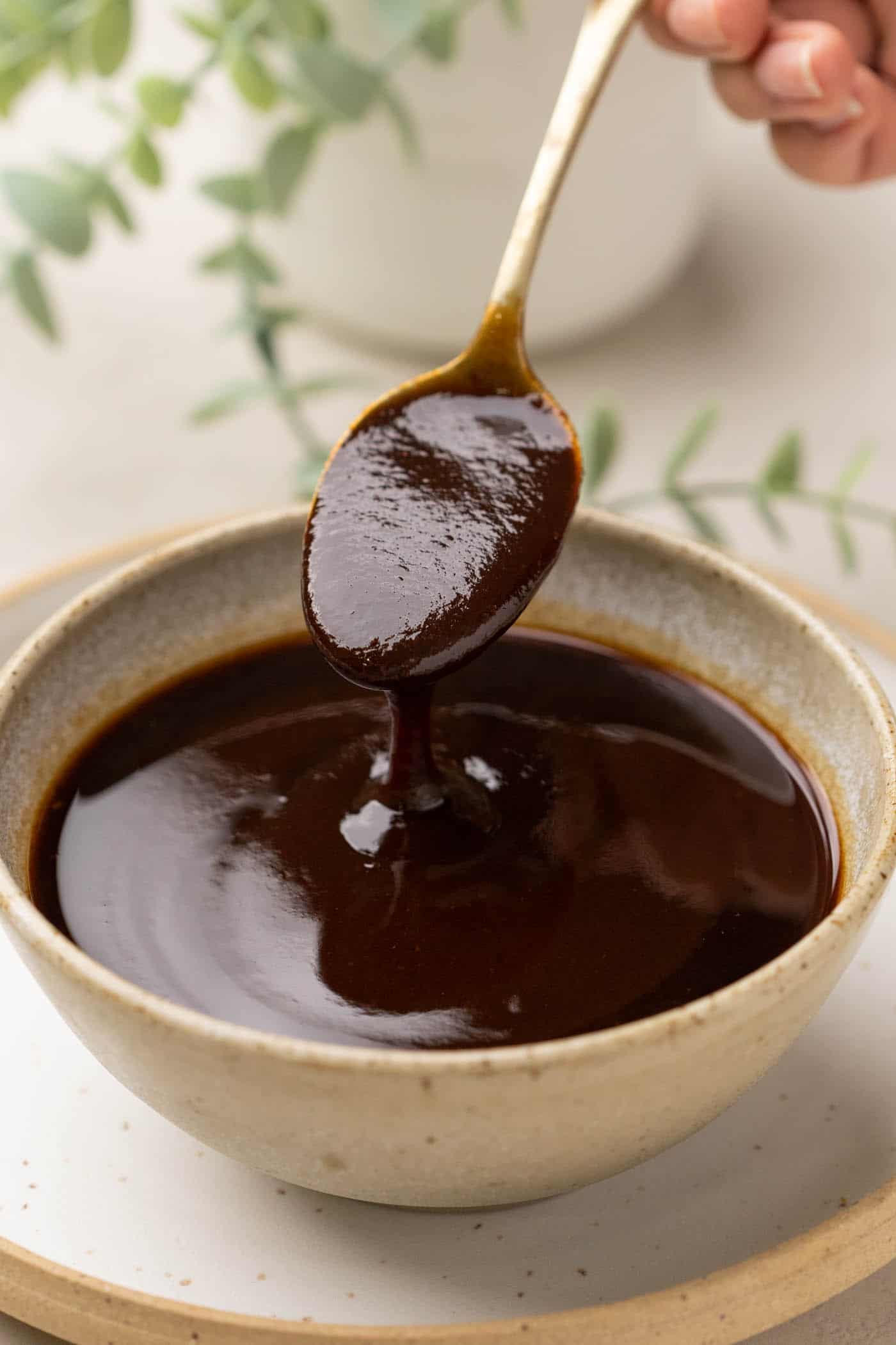 Tamarind Chutney being poured from a spoon into a bowl to show the texture