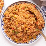 Picture of chilli garlic fried rice served on a white and blue plate
