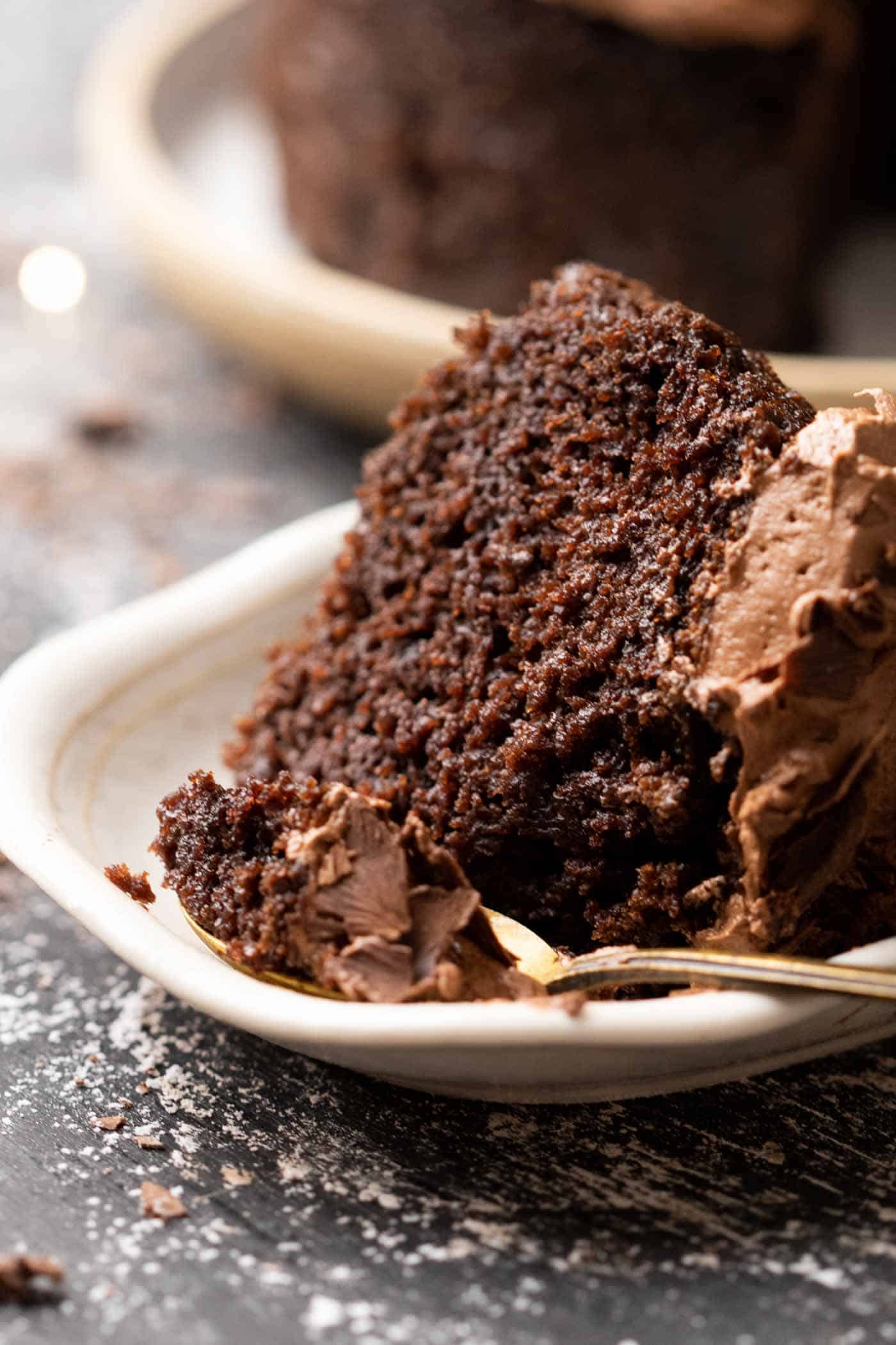 picture of a slice of chocolate cake topped with chocolate buttercream with a spoon