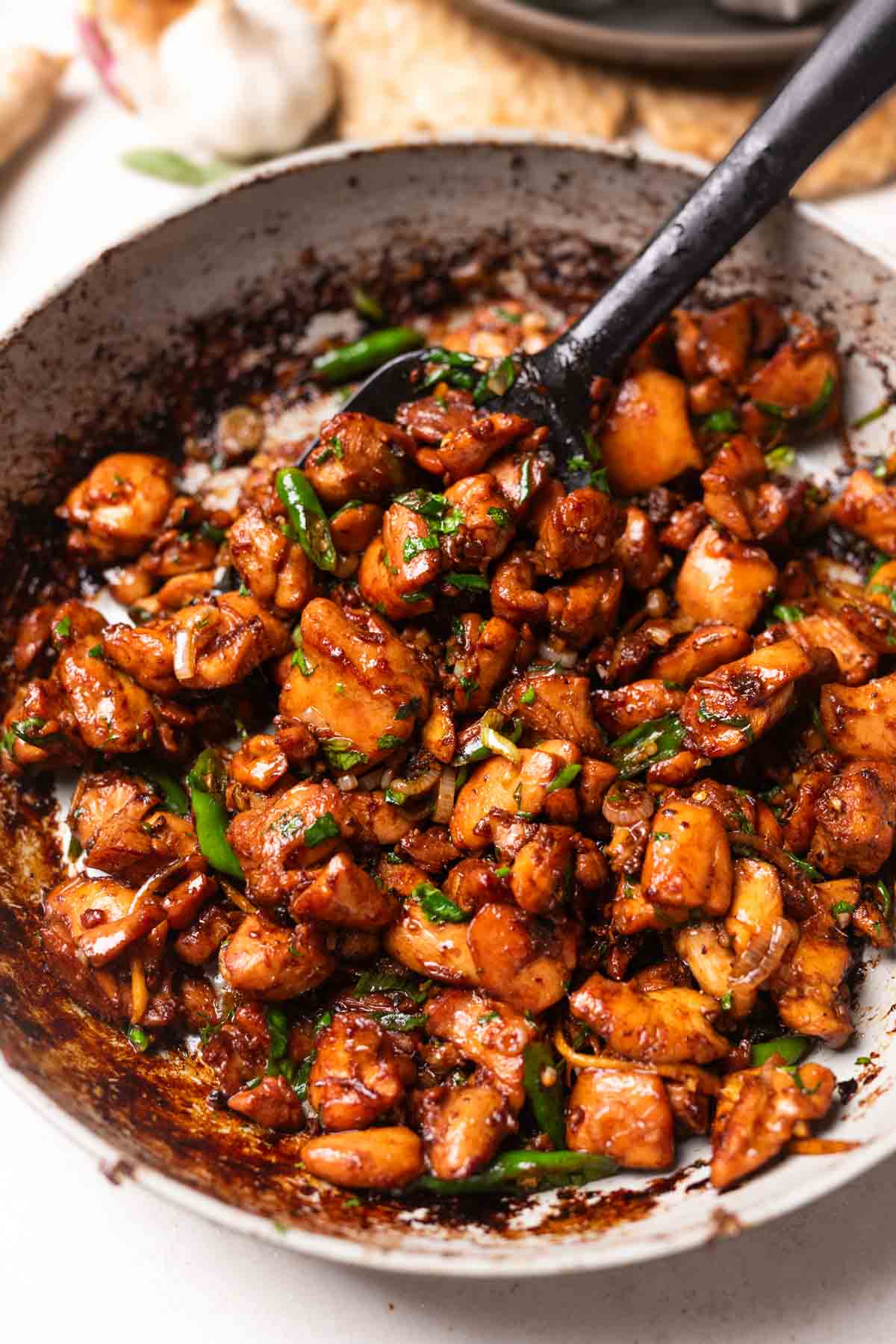 an image of ginger chicken stir fry served in a bowl along with a spoon