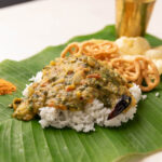 rice served on banana leaf with andhra pappu, with fryums and chutney podi