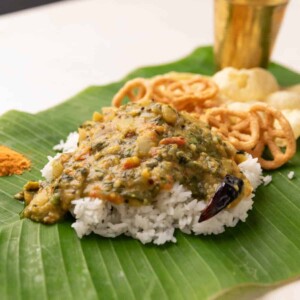 rice served on banana leaf with andhra pappu, with fryums and chutney podi