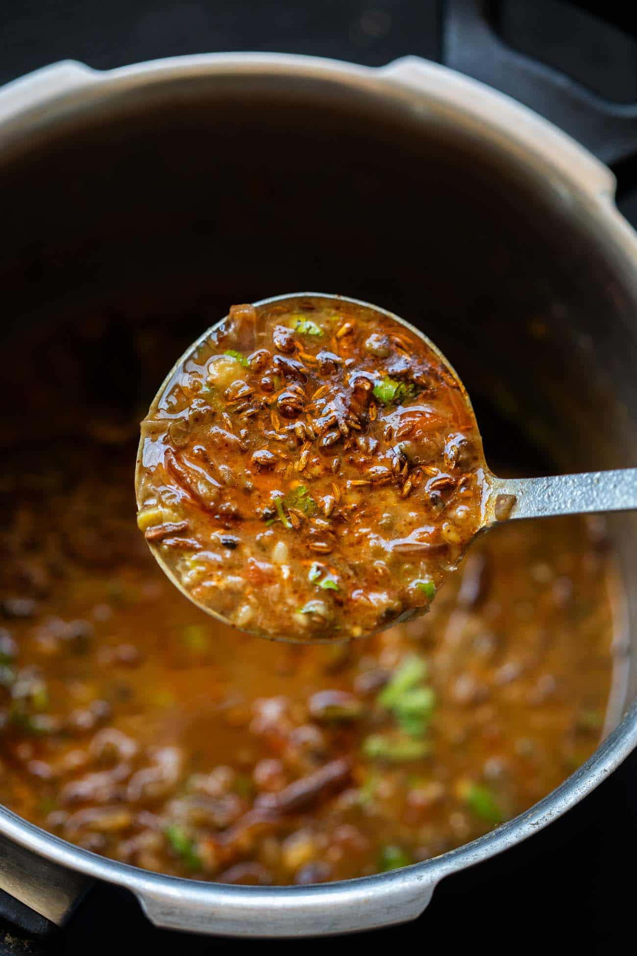 Closeup of a ladleful of Dhaba style mixed dal to show the texture