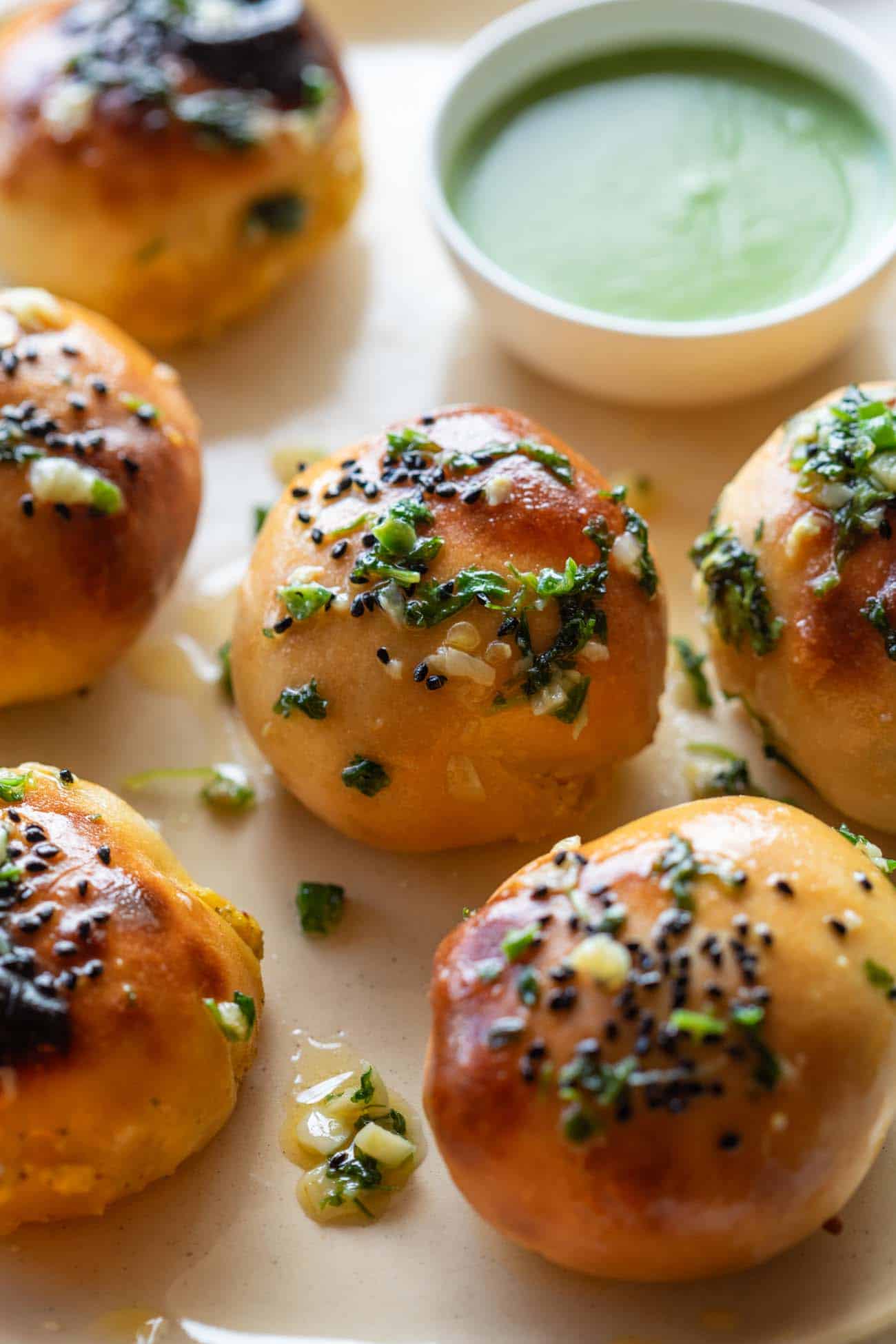 Close up of achari paneer naan bomb with mint chutney in the background